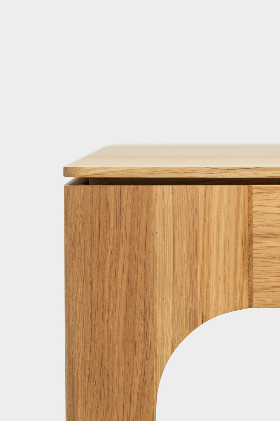 Schwebende Tischplattenoptik mit Schattenfuge und gebogenen Beinen.